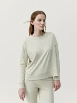 Sudadera deportiva color verde claro, de patrón holgado y aberturas laterales.