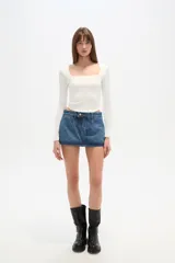 Remera blanca de manga larga y corte ajustado al cuerpo, con escote cuadrado.