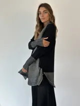 Saco negro de algodón con diseño de rayas horizontales grises en la parte delantera y en los puños.