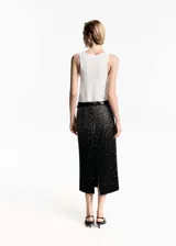 Falda midi negra con cintura elástica, tiro medio, diseño recto y detalle de strass plateado.