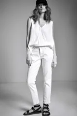 Pantalón blanco de denim, corte slim y tiro medio.