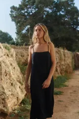 Vestido midi negro de lino y rayón con tiras finas ajustables, escote recto y tajo lateral.