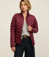 Campera puffer ultraligera color marrón, confeccionada en poliamida acolchada, con cuello alto y cierre por cremallera. Incluye bolsita con cordón.
