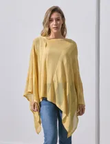 Poncho blanco de tejido calado con lurex, terminación asimétrica y cuello redondo.