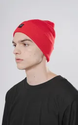 Gorro de lana rojo con logo de tijeras en un recuadro negro.