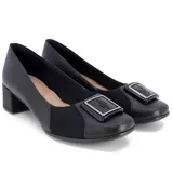 Zapato de cuero negro con taco cuadrado bajo, detalle de elástico y aplique metálico en el empeine.