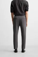 Pantalón color arena de corte recto, confeccionado en tejido elástico. Cuenta con cintura elástica ajustable con cordón, bolsillos laterales y bolsillos de vivo en la parte trasera.