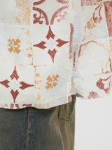 Camisa de manga corta con cuello resort y fit amplio, confeccionada en tejido plano de lino y algodón. Presenta un estampado de mosaicos en tonos rojo, naranja, azul y blanco.