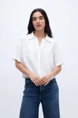 Blusa verde con escote en V, cuello camisero, manga corta y dos bolsillos en el pecho.