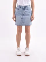 Minifalda de jean celeste con diseño de cinco bolsillos, cierre frontal con botón y cremallera, y ruedo desflecado.