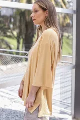 Remera color amarillo claro de viscosa, corte holgado, mangas 3/4 y cuello redondo.