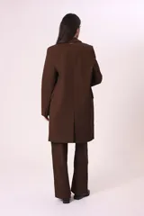 Blazer largo marrón con solapas de muesca, cierre frontal con dos botones y bolsillos laterales con solapa.