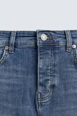 Pantalón de jean negro ajustado al cuerpo desde la cintura hasta el tobillo, de tiro medio y tejido elástico. Diseño de cinco bolsillos con lavado efecto roto y cierre frontal con cremallera y botón.
