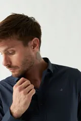 Camisa de vestir azul marino, de corte slim fit, manga larga y cuello clásico. Confeccionada en algodón y con logo bordado en el pecho.