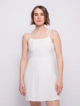 Vestido corto sin mangas de tirantes finos, confeccionado en tela de textura diferenciada.