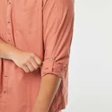 Camisa de manga larga color salmón con cuello mao y bolsillo en el pecho.