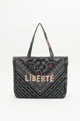 Bolso tipo tote bag negro con estampado geométrico multicolor y la palabra 'Liberté' bordada en dorado.