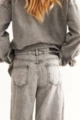 Jean de denim gris claro, de corte extra wide con pretina desflecada y bajo descosido.