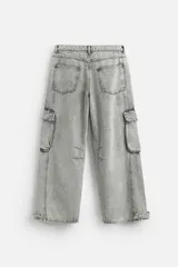 Pantalón relaxed fit confeccionado en denim de algodón celeste con efecto lavado. Cuenta con bolsillos frontales, traseros de plastrón y bolsillos multifunción en las perneras. El bajo es ajustable con trabilla. Cierre frontal con cremallera y botón.