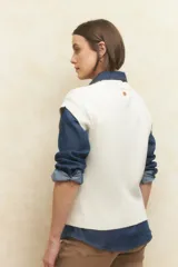 Chaleco tejido de algodón color beige, sin mangas, con diseño de trenzas y calados.