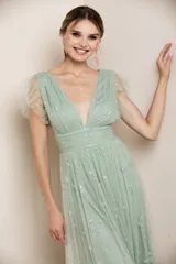 Vestido largo de fiesta color azul acero, con escote en V, mangas cortas de tul fruncido y falda de tul con abertura lateral y estampado de estrellas plateadas.