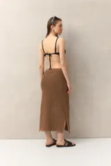 Falda larga de tejido de punto marrón con sutil brillo metalizado y tajo lateral.