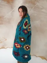 Saco de lana marrón con diseño geométrico multicolor, cuello con solapa, cierre frontal con botones y bolsillos delanteros.