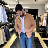 Campera tejida gris con cierre frontal, cuello alto y bolsillos laterales.
