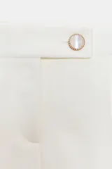 Falda pantalón corta color blanco, de tiro bajo, con bolsillos delanteros y cierre frontal con cremallera y botón joya.