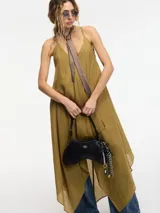 Vestido negro con escote en V y breteles finos. Corte evasé amplio con caída en picos.