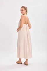 Vestido largo color beige, de corte recto y breteles finos.