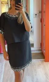 Falda blanca de lino y algodón, corte mini y bordado con lentejuelas plateadas en el ruedo.