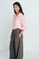 Camisa rosa de lino liviano, de corte recto, con cuello clásico, botones frontales, manga larga con puños abotonados, canesú en la espalda, bolsillo de parche en el pecho y bajo redondeado.