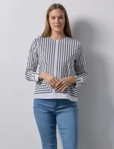 Blusa de gasa estampada a rayas verticales blancas y negras, marca Sioni. Espalda con abertura y botón. Manga larga con puño y botón.