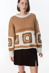 Sweater azul con cuello redondo y diseño de cuadrados de crochet en la parte inferior.