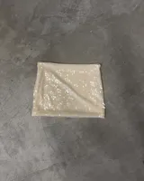 Minifalda tubo color beige claro cubierta de lentejuelas brillantes.