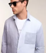Camisa de hombre de corte clásico, confeccionada en tejido oxford con bloques de color celeste y gris. Cuenta con cuello tradicional, abotonadura frontal, mangas largas y bolsillo de parche en el pecho.
