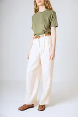 Pantalón negro de corte ancho y tiro alto, con pinzas en la cintura y bolsillos laterales.