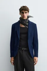 Blazer straight fit color gris claro confeccionada en tejido con viscosa. Cuello con solapas de muesca y manga larga acabada en puño con botón. Bolsillo de vivo en pecho y bolsillos de plastrón en cadera. Bajo con aberturas en espalda. Cierre frontal de botonadura.