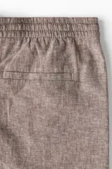 Short marrón claro en tejido liviano de lino y algodón. Modelo con elástico revestido y cordón para ajustar en la cintura, cierre con botón, bolsillos laterales y bolsillo insertado atrás.