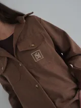 Camisa gris de lana con corte clásico, cuello camisero, cierre frontal con botones de cuerno y dos bolsillos de parche en el pecho.