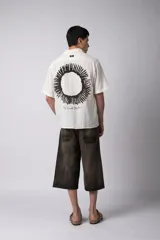 Camisa blanca de lino con cuello clásico, manga corta y cierre frontal con botones.