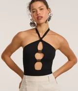 Body negro de microfibra con escote halter, lazo en el cuello, recortes circulares con adornos metálicos y cierre con broches en la entrepierna.