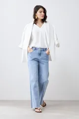 Blusa color crudo con escote en V y mangas largas.