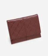 Billetera sobre color bordó con textura de triángulos en relieve y separadores internos para tarjetas y documentos.