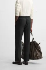 Pantalón negro regular fit confeccionado en tejido de lino. Cintura ajustable con cordón interior, bolsillos frontales y detalle de bolsillos traseros de vivo.