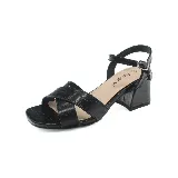 Sandalias negras con textura tipo piel de cocodrilo, con dos tiras anchas cruzadas en el empeine y pulsera al tobillo con hebilla. Tacón ancho y bajo.