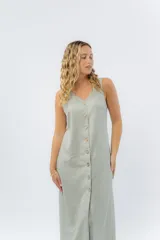 Vestido midi de lino en color verde seco, con escote en V, diseño sin mangas y cierre frontal con botones de madera. Presenta un corte recto y fluido con una abertura frontal en el bajo.