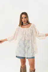 Blusa color crudo con bordado de flores, escote cuadrado y mangas 3/4 abullonadas.