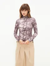 Polera de cuello alto con estampado de piel de serpiente en tonos lila y marrón.